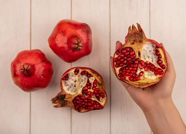 Pomegranates cut open showing seeds — pomegranate polyphenols are among the strongest natural boosters of Akkermansia muciniphila